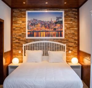 a bedroom with a white bed with a brick wall at Spacious Villa with Private Pool in Oliveira de Azeméis in Oliveira de Azemeis