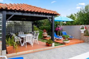 a patio with a table and chairs and an umbrella at Spacious Villa with Private Pool in Oliveira de Azeméis in Oliveira de Azemeis