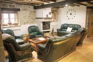 a living room with leather furniture and a fireplace at Charming House in La Cavada with Jacuzzi in La Cavada