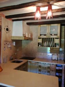 a kitchen with wooden cabinets and a sink and lights at Charming House in La Cavada with Jacuzzi in La Cavada +14 photos