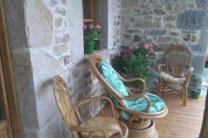 two chairs sitting on a porch with flowers at Charming House in La Cavada with Jacuzzi in La Cavada