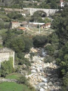 a river of rocks in a town with a bridge at Charming Apartment in Alvoco da Serra with Mountain View in Alvoco da Serra +9 photos