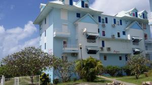 a large white building with a clock on it at Appartement moderne à Sainte-Anne 43 m² avec vue mer in Sainte-Anne