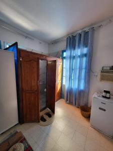 a room with a door and a room with a refrigerator at Dar Essadeg Bis in Tataouine