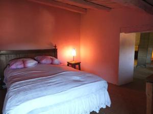 a bedroom with a bed with an orange wall at Appartement raffiné à Feliceto - 120 m² avec vue sur montagne in Feliceto