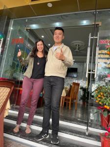 a man and a woman standing in front of a store at SunWay hotel in Cat Ba