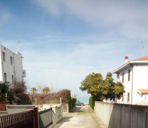 a street with houses and a fence and the ocean at Charming house with sea view in Contrada Termini in Casalbordino +16 photos