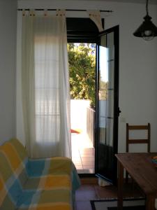 a room with a door open to a patio with a table at Charming apartment with mountain view in Jabuguillo, 70 m² in Aracena