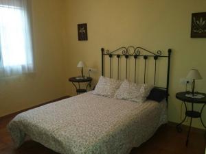 a bedroom with a bed and two tables with lamps at Charming apartment with mountain view in Jabuguillo, 70 m² in Aracena