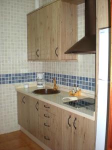 a kitchen with wooden cabinets and a sink at Charming apartment with mountain view in Jabuguillo, 70 m² in Aracena