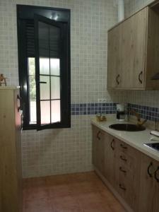 a kitchen with a sink and a window at Charming apartment with mountain view in Jabuguillo, 70 m² in Aracena