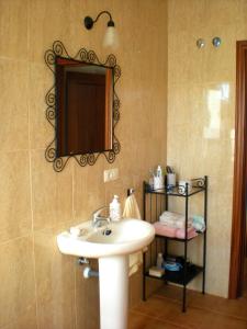 a bathroom with a sink and a mirror on the wall at Charming apartment with mountain view in Jabuguillo, 70 m² in Aracena +11 photos