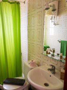 a bathroom with a green shower curtain and a sink at Modern apartment in Frontera, 45 m² with sea view balcony in Frontera