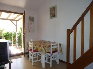 a dining room with a table and chairs and a staircase at Maison conviviale à Argelès-sur-Mer avec piscine partagee 35 m² in Argelès-sur-Mer