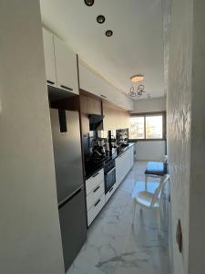 a kitchen with white cabinets and a stove top oven at Flowers in Bouznika +4 photos