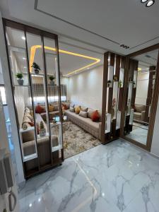 a living room with a couch and a large mirror at Flowers in Bouznika