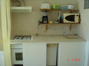 a small kitchen with a stove and a sink at Appartement spacieux à Bois des Nèfles, 70 m², piscine partagée in Le Bois de Nèfles