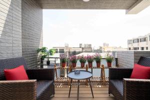 a balcony with chairs and a table and some plants at Yuan Lu Homestay in Lukang
