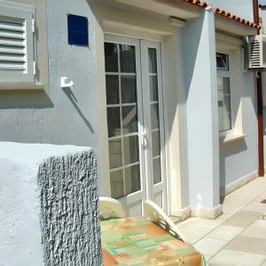 a door of a house with a table next to it at Charming apartment in Kampor with private garden - 28 m² in Kampor