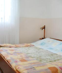 an unmade bed in a bedroom with a window at Charming apartment in Kampor with private garden - 28 m² in Kampor