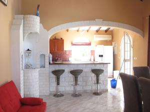 a kitchen with a counter and stools in a room at Spacieuse villa à Deshaies avec piscine privée in Deshaies