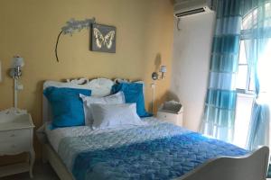 a bedroom with a blue bed with blue pillows at Spacieuse villa à Deshaies avec piscine privée in Deshaies