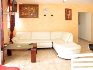 a living room with a white couch and a table at Spacieuse villa à Deshaies avec piscine privée in Deshaies