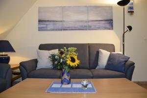 a living room with a couch and a vase with a sunflower at Waack, Brigitte App Nr 7 in Schönberger Strand
