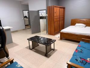 a bedroom with a bed and a table in a room at Panatina Sunset Residence in Honiara