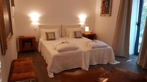 a bedroom with a white bed with two pillows on it at Picturesque Villa in Santo António das Areias with Private Pool in Marvão