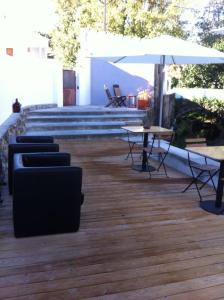 a patio with tables and chairs and an umbrella at Picturesque Villa in Santo António das Areias with Private Pool in Marvão