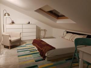 a bedroom with a bed and a chair and a dresser at Picturesque Villa in Santo António das Areias with Private Pool in Marvão