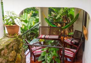 two chairs and a table on a balcony with plants at Charming house in Victoria with mountain view in Victoria