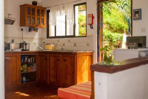 a kitchen with wooden cabinets and a sink and a window at Charming house in Victoria with mountain view in Victoria +11 photos