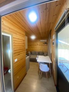 ein kleines Zimmer mit einem Tisch und einem Sofa in der Unterkunft Violet Village in Borsh