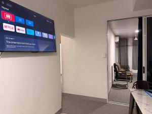 a room with a tv on the wall with a chair at Panatina Sunset Residence in Honiara