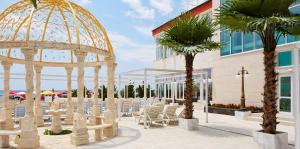 a gazebo with chairs and palm trees in front of a building at Coastal Studio with Sea View in Elenite, 40m² + Pool in Elenite +24 photos