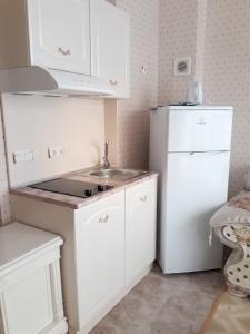 a white kitchen with a sink and a refrigerator at Coastal Studio with Sea View in Elenite, 40m² + Pool in Elenite