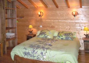 a bedroom with a bed in a room with wooden walls at Maison charmante à Saint-Cirq avec piscine privée in Saint-Cirq