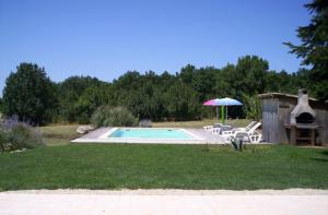 a pool with chairs and an umbrella and a table at Maison charmante à Saint-Cirq avec piscine privée in Saint-Cirq +21 photos