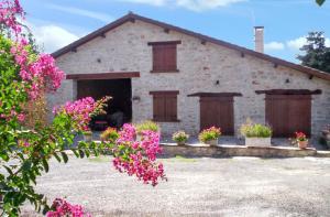 a stone house with flowers in front of it at Maison charmante à Saint-Cirq avec piscine privée in Saint-Cirq