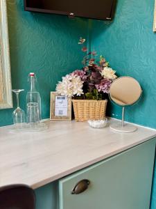 a counter with a vase of flowers and a bottle at The Wadham in Weymouth