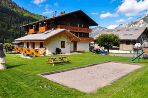 a house in the mountains with a playground at Appartement confortable à La Chapelle-d'Abondance 75 m² avec jardin in La Chapelle-dʼAbondance