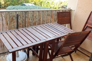 a wooden table and two chairs on a balcony at Appartement cosy à Gruissan, piscine partagée, 25 m² in Gruissan