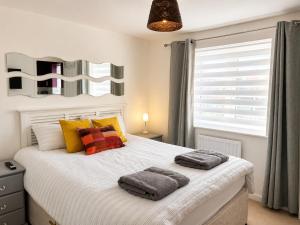 a bedroom with a bed with two towels on it at Chilton Charm Modern 3BR Ideal for Long Stays in Chilton