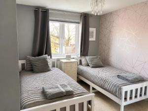 a bedroom with two beds and a window at Chilton Charm Modern 3BR Ideal for Long Stays in Chilton +10 photos