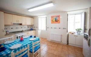 a kitchen with a table with a blue table cloth at Charming house in Teo with balcony and parking included in Rua De Francos