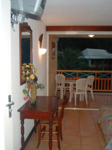 a living room with a table and a balcony at Studio charmant à Sainte-Anne de 25 m² avec terrasse et jardin. in Sainte-Anne