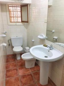 a white bathroom with a toilet and a sink at Charming Apartment in Albuñol, 90 m², Near Amenities in Albuñol +22 photos