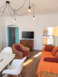 a living room with a couch and a tv at Appartement charmant à Algajola avec terrasse in Algajola